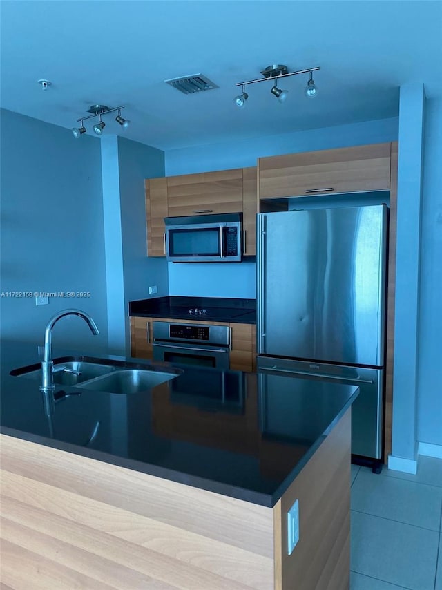 kitchen featuring sink, light tile patterned floors, and stainless steel appliances