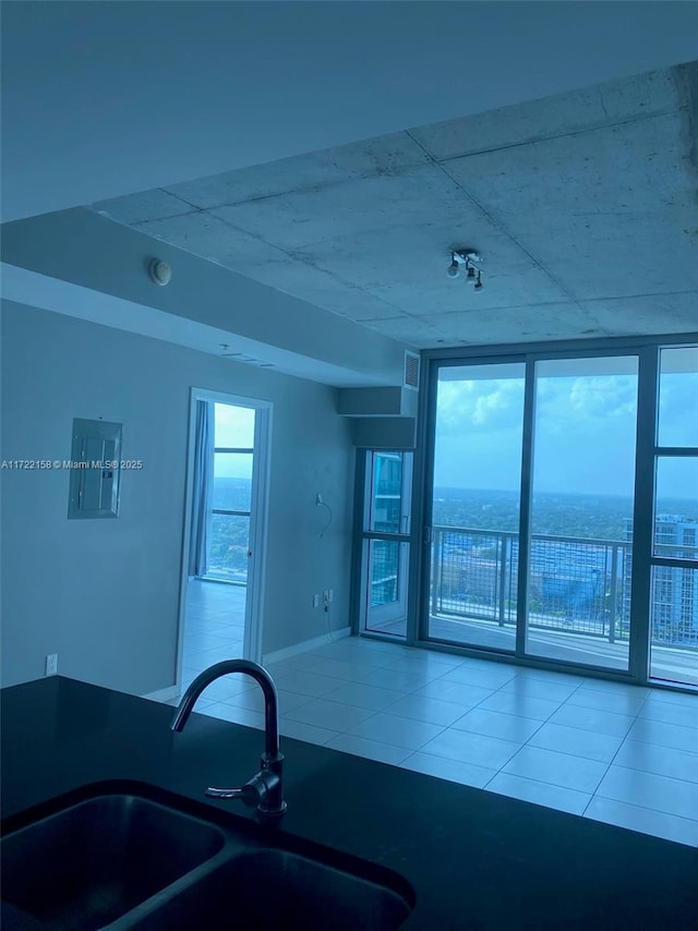 kitchen with expansive windows, a water view, sink, and electric panel