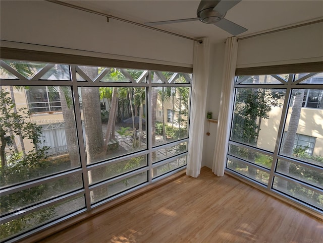 unfurnished sunroom with ceiling fan