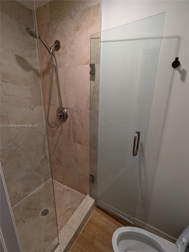 bathroom with wood-type flooring and a shower with door