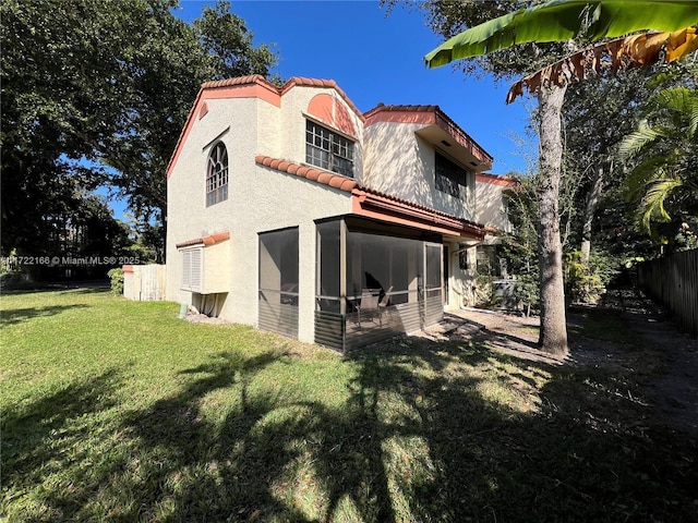 rear view of property with a sunroom and a yard