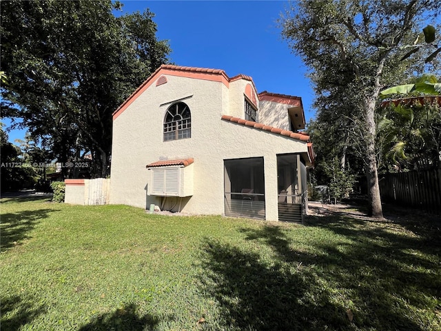 back of house with a sunroom and a yard