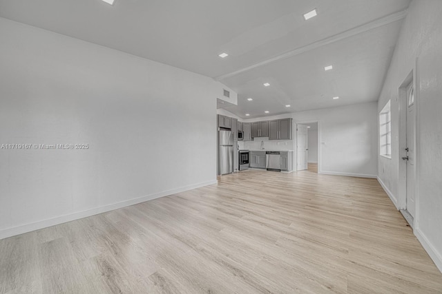 unfurnished living room featuring light hardwood / wood-style floors and vaulted ceiling