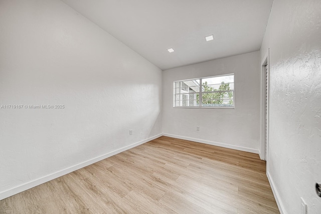 empty room featuring light hardwood / wood-style floors and lofted ceiling