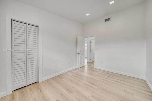 unfurnished bedroom featuring a closet and light hardwood / wood-style flooring