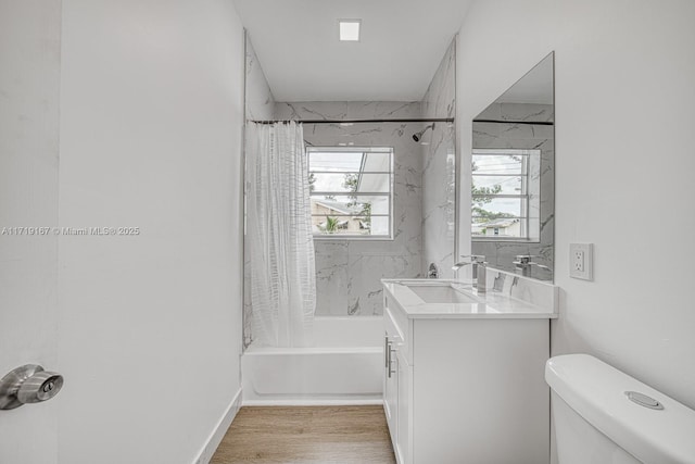 full bathroom with hardwood / wood-style floors, vanity, toilet, and shower / tub combo