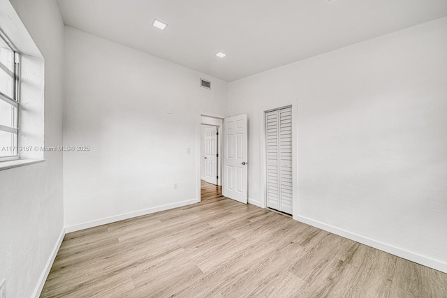 unfurnished bedroom featuring light hardwood / wood-style floors and a closet