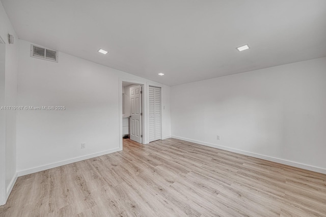 spare room featuring light hardwood / wood-style flooring and lofted ceiling