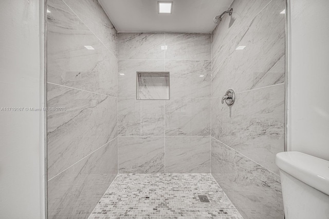 bathroom with toilet and tiled shower