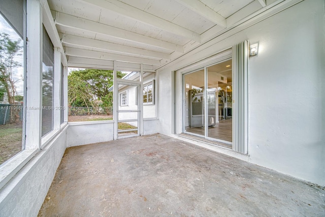 unfurnished sunroom with beam ceiling