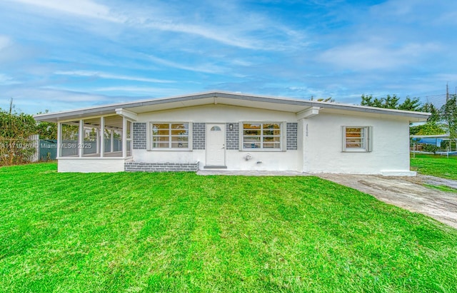 back of house featuring a lawn and a sunroom