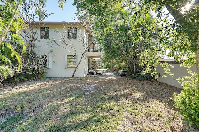 view of yard featuring a balcony and fence