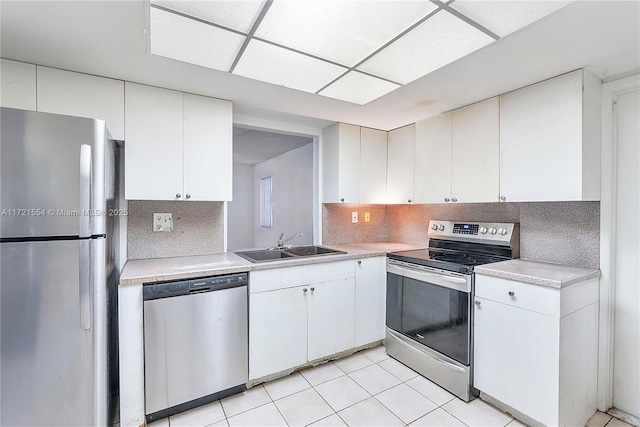 kitchen with backsplash, stainless steel appliances, light countertops, and a sink