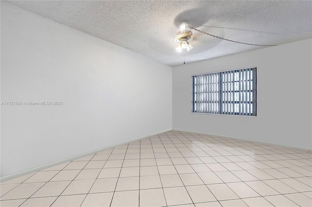 spare room with a ceiling fan, baseboards, and a textured ceiling