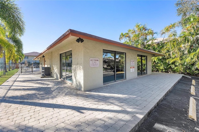 back of property with central AC and a patio area