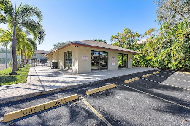 view of property with uncovered parking and fence