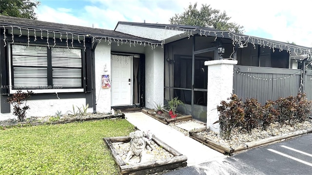 doorway to property with a lawn