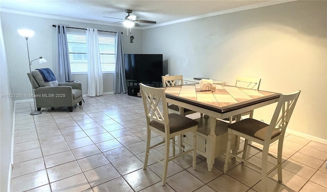 dining area featuring ceiling fan, crown molding, and light tile patterned floors