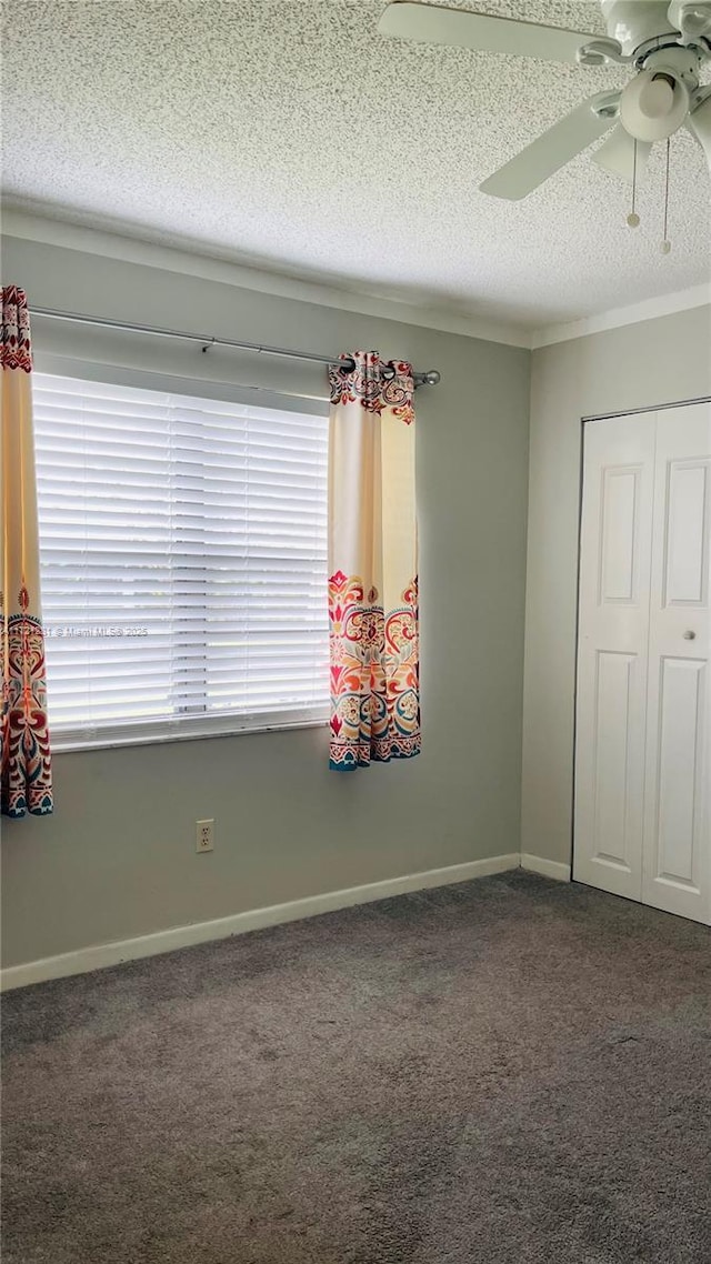 carpeted empty room with a textured ceiling and ceiling fan