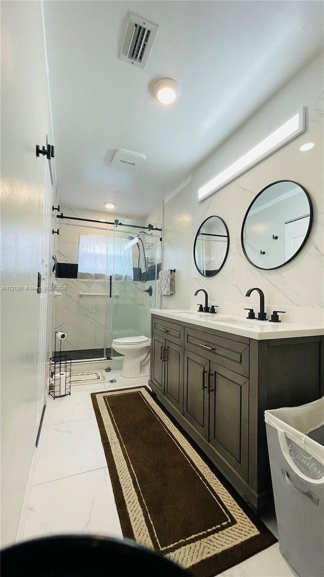 bathroom with vanity, a shower with door, and toilet