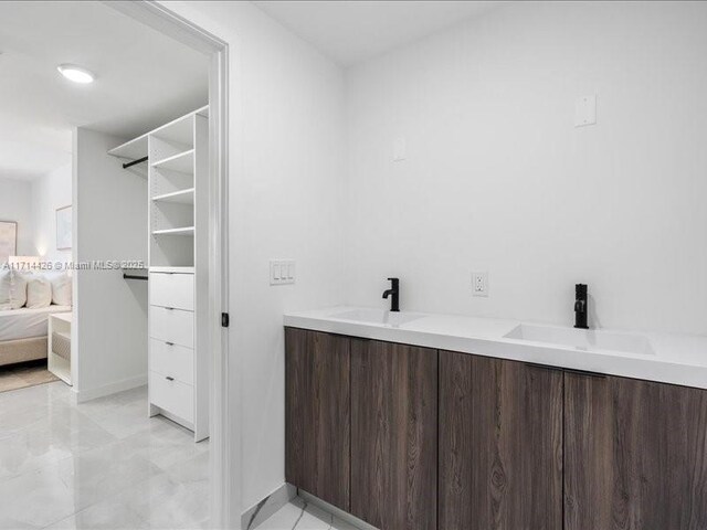 bathroom with a tile shower, vanity, and toilet