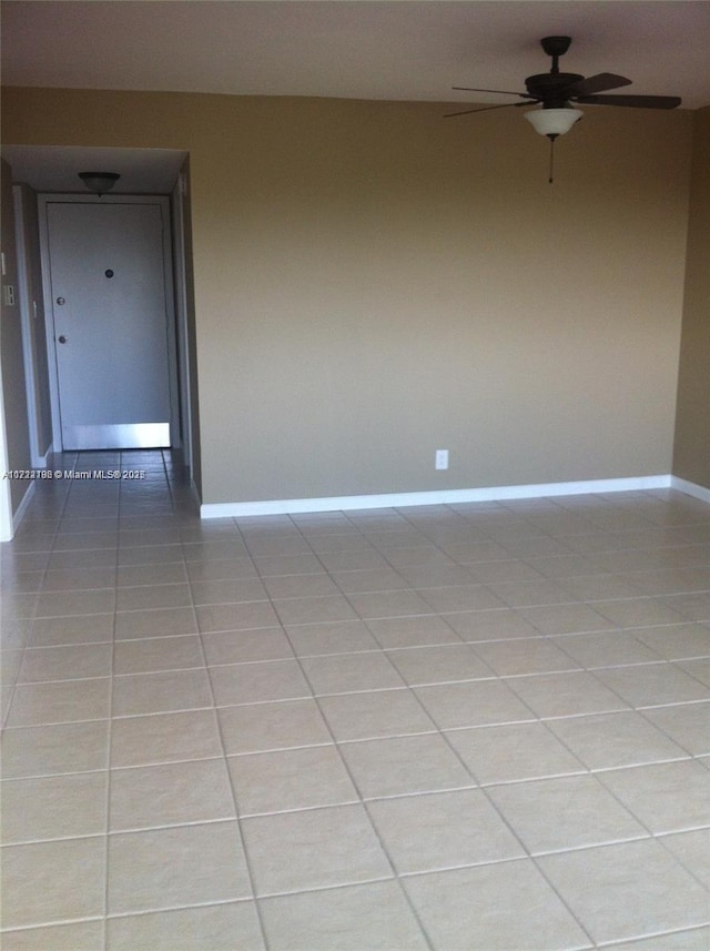 tiled empty room featuring ceiling fan