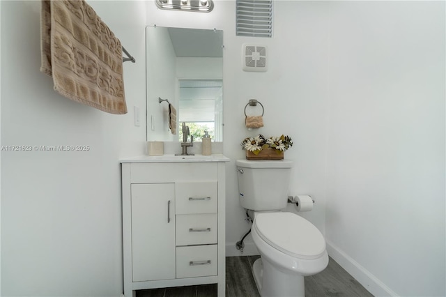 bathroom with vanity, hardwood / wood-style flooring, and toilet