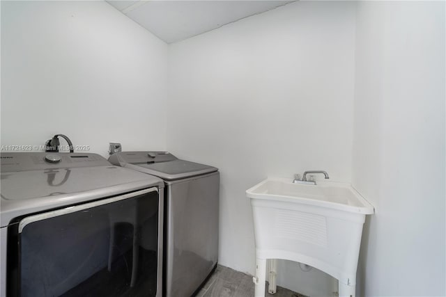 laundry area featuring sink, light wood-type flooring, and independent washer and dryer