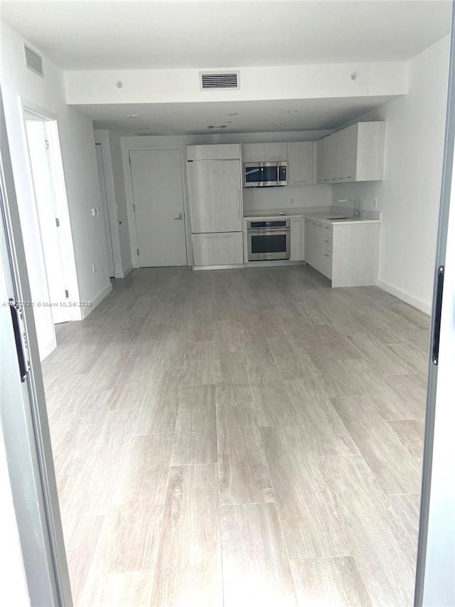 unfurnished living room featuring light hardwood / wood-style floors and sink