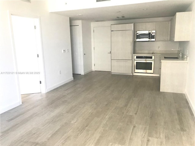 kitchen featuring wood-type flooring, appliances with stainless steel finishes, and sink