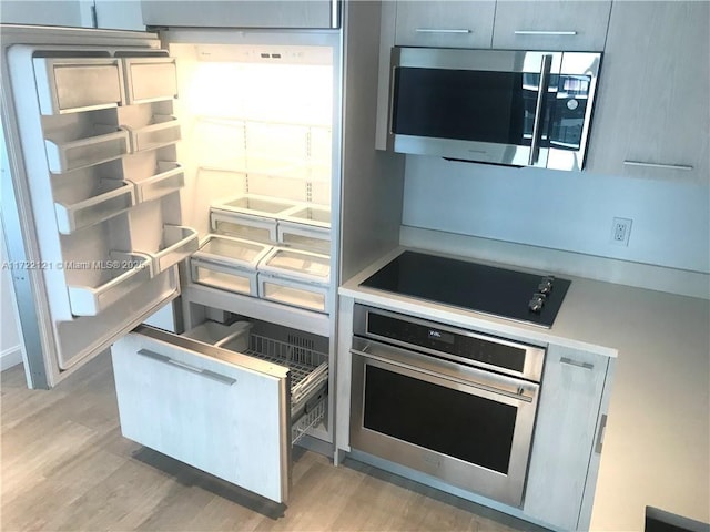 kitchen featuring appliances with stainless steel finishes and light hardwood / wood-style flooring