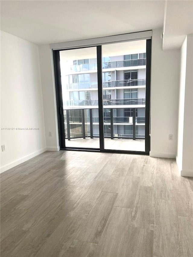 empty room featuring hardwood / wood-style flooring and expansive windows