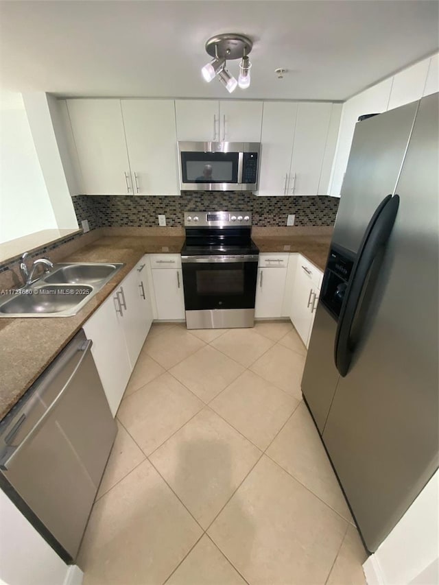 kitchen with white cabinets, backsplash, sink, and appliances with stainless steel finishes