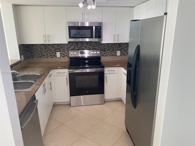 kitchen with backsplash, white cabinets, and stainless steel appliances