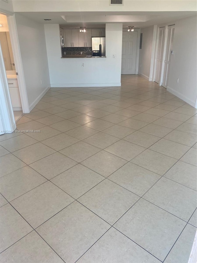 unfurnished living room featuring light tile patterned floors and ceiling fan