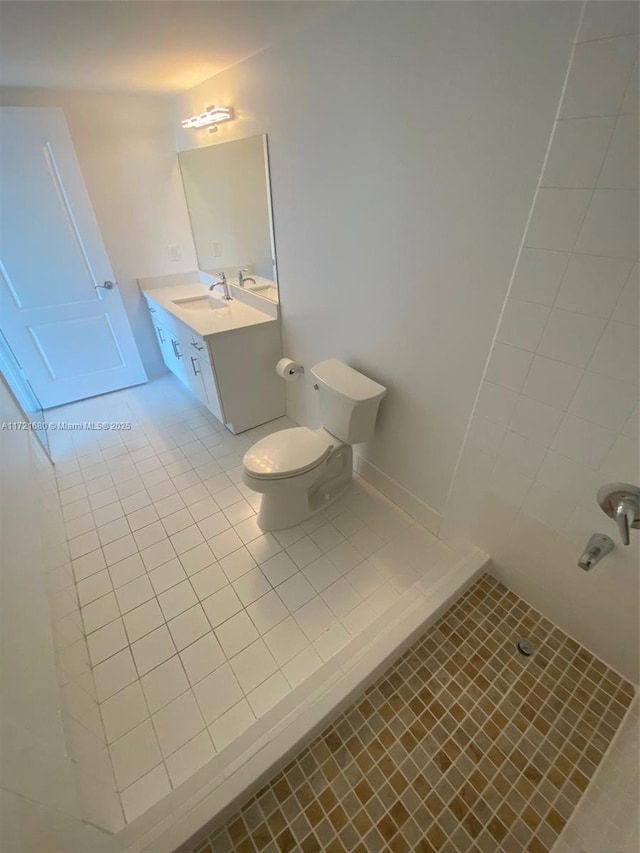 bathroom with tile patterned flooring, a shower, vanity, and toilet