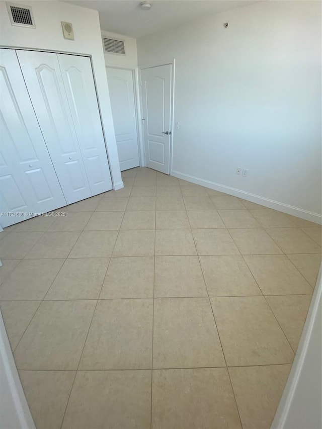 unfurnished bedroom featuring light tile patterned floors and a closet