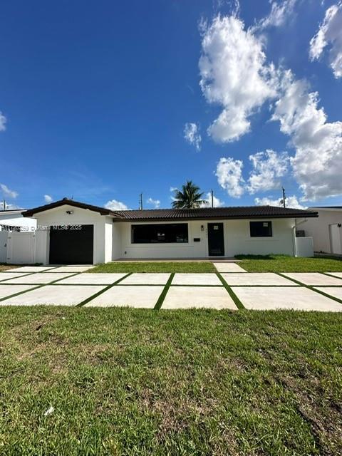 single story home featuring a front lawn and a garage