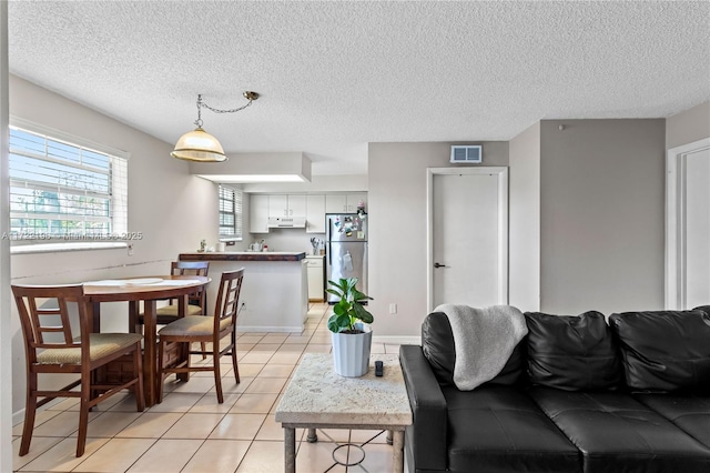 tiled living room featuring a textured ceiling