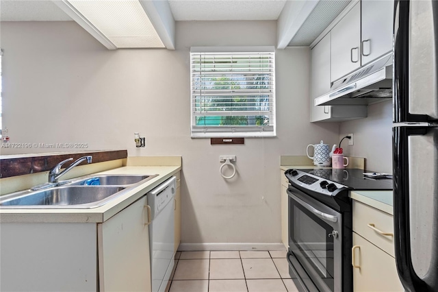 kitchen with stainless steel range with electric stovetop, dishwasher, sink, fridge, and light tile patterned flooring