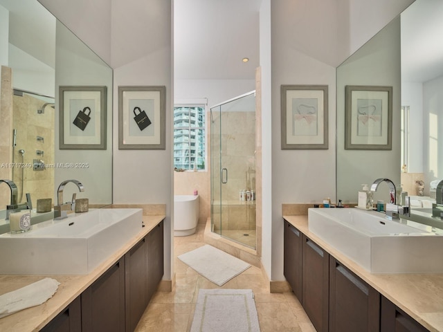 bathroom featuring a stall shower, a freestanding tub, two vanities, and a sink