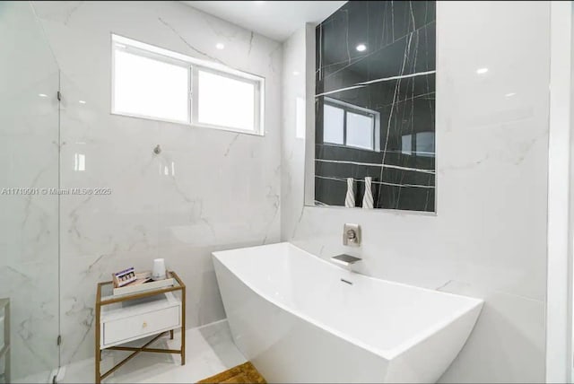 bathroom with tile walls and a tub