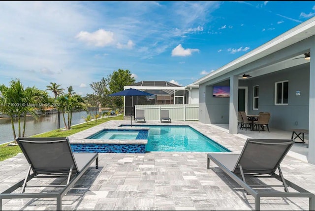 view of swimming pool with an in ground hot tub, a water view, and a patio