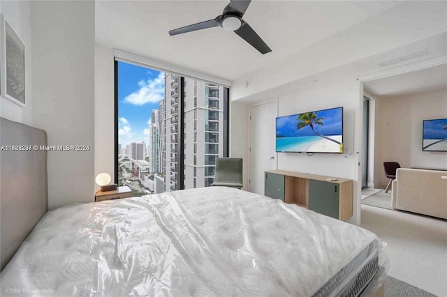 bedroom featuring ceiling fan, expansive windows, and access to exterior