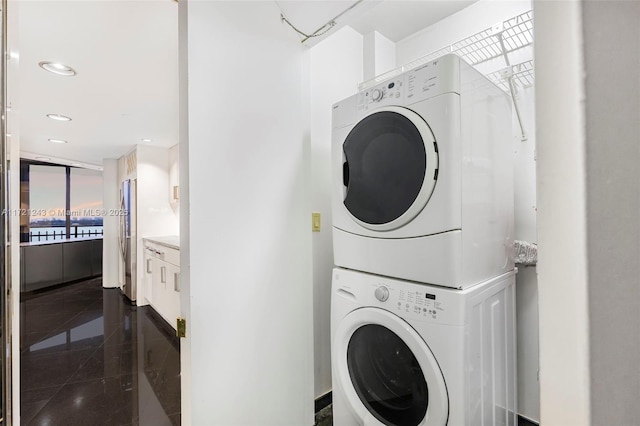 clothes washing area featuring stacked washing maching and dryer