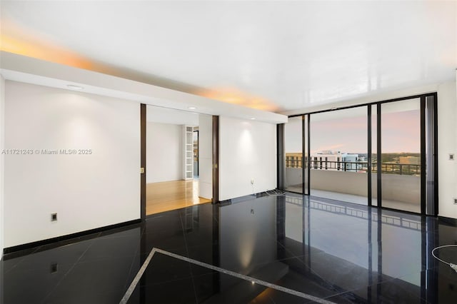 tiled empty room featuring floor to ceiling windows