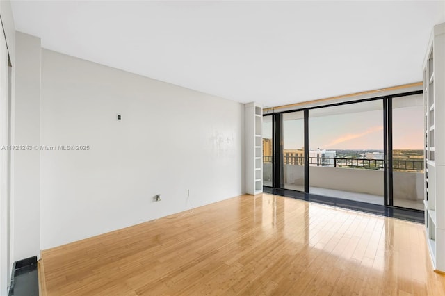 spare room with light hardwood / wood-style floors and floor to ceiling windows