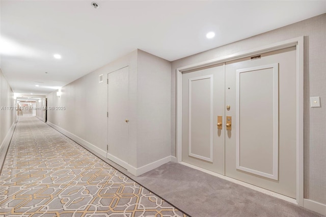 hallway featuring light colored carpet