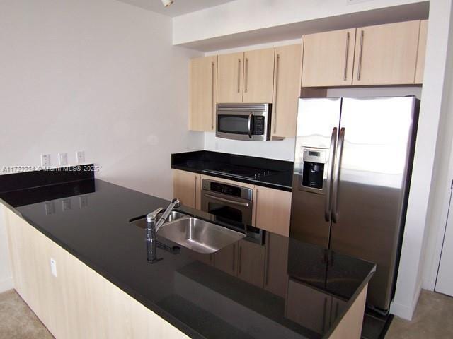 kitchen featuring light brown cabinets, stainless steel appliances, and sink