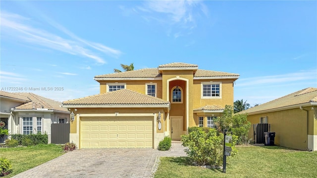 mediterranean / spanish home with a garage and a front lawn